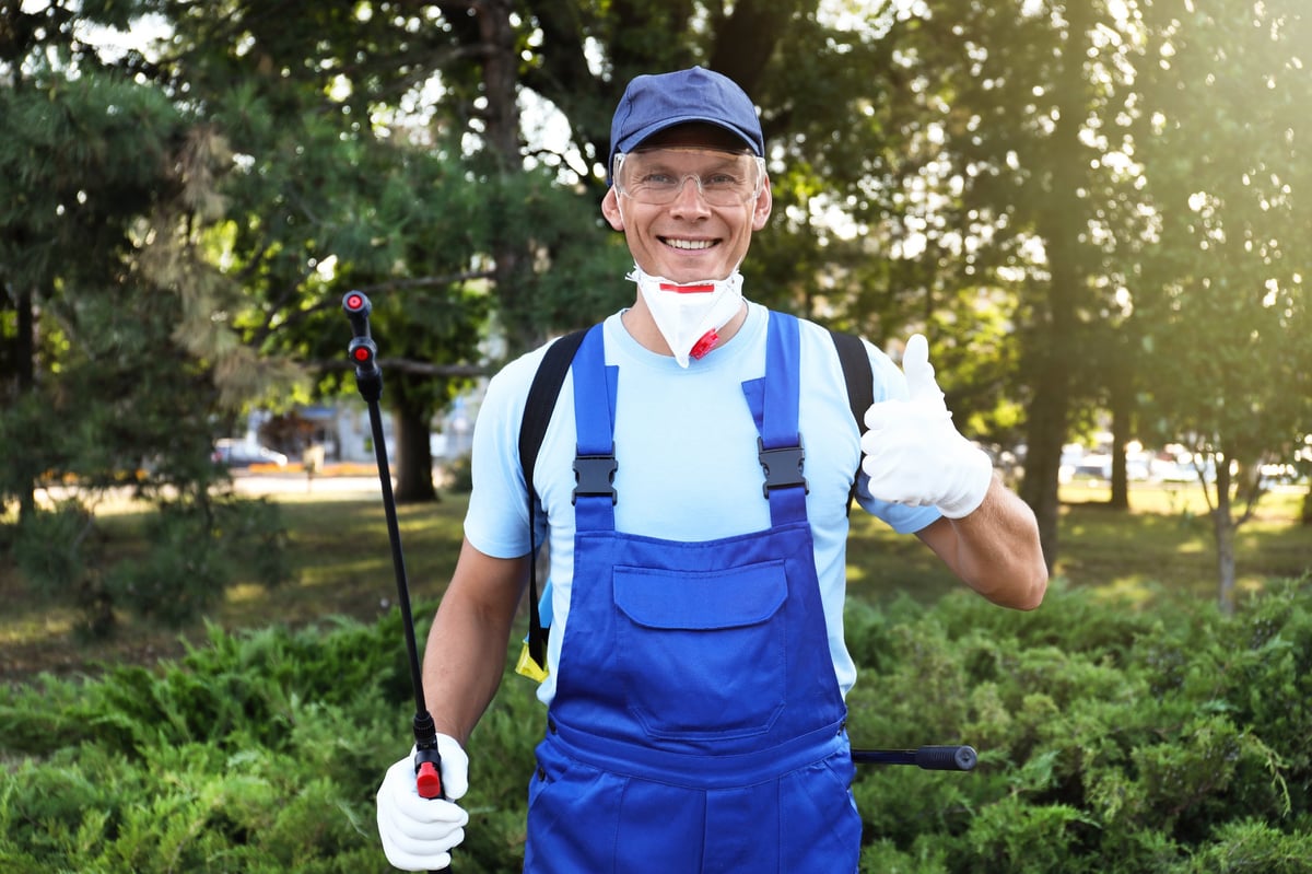 Pest control specialist treating a residential exterior