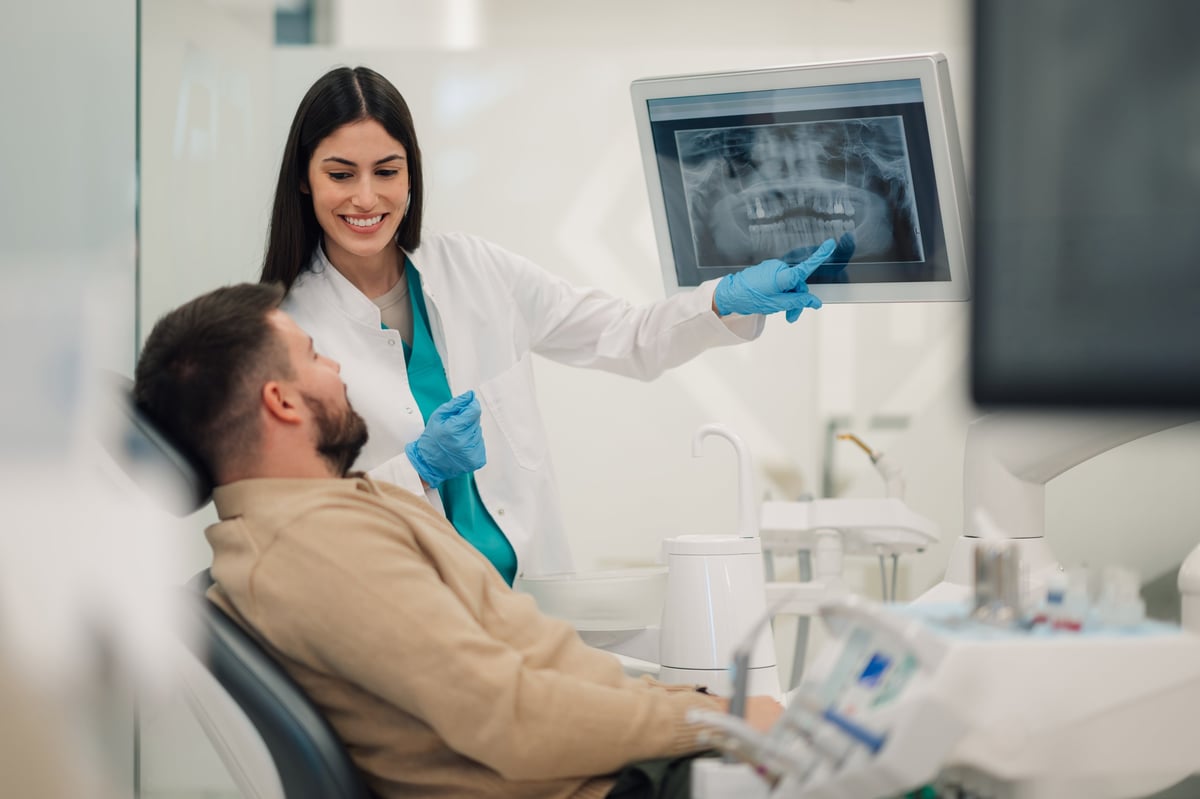 Dentist showing a dental x-ray to a patient