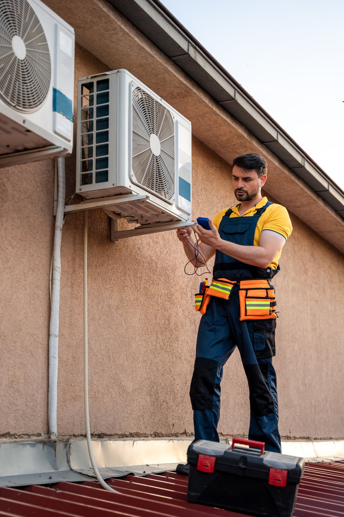 HVAC technician on a rooftop inspecting and maintaining air conditioning units