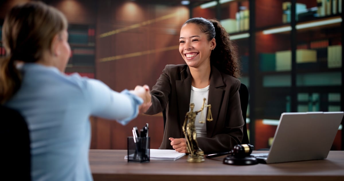 Handshake between an attorney and a client in a law office, closing a consultation