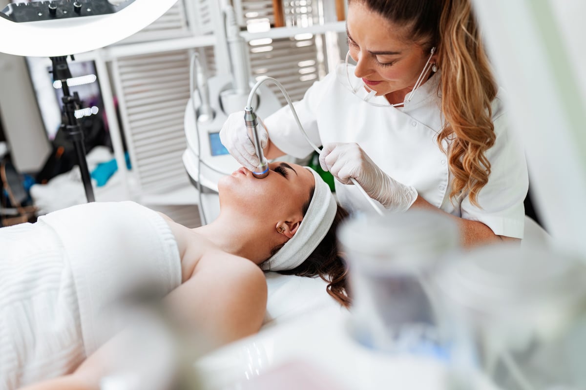 Relaxed woman receiving a professional facial treatment at a modern medical spa