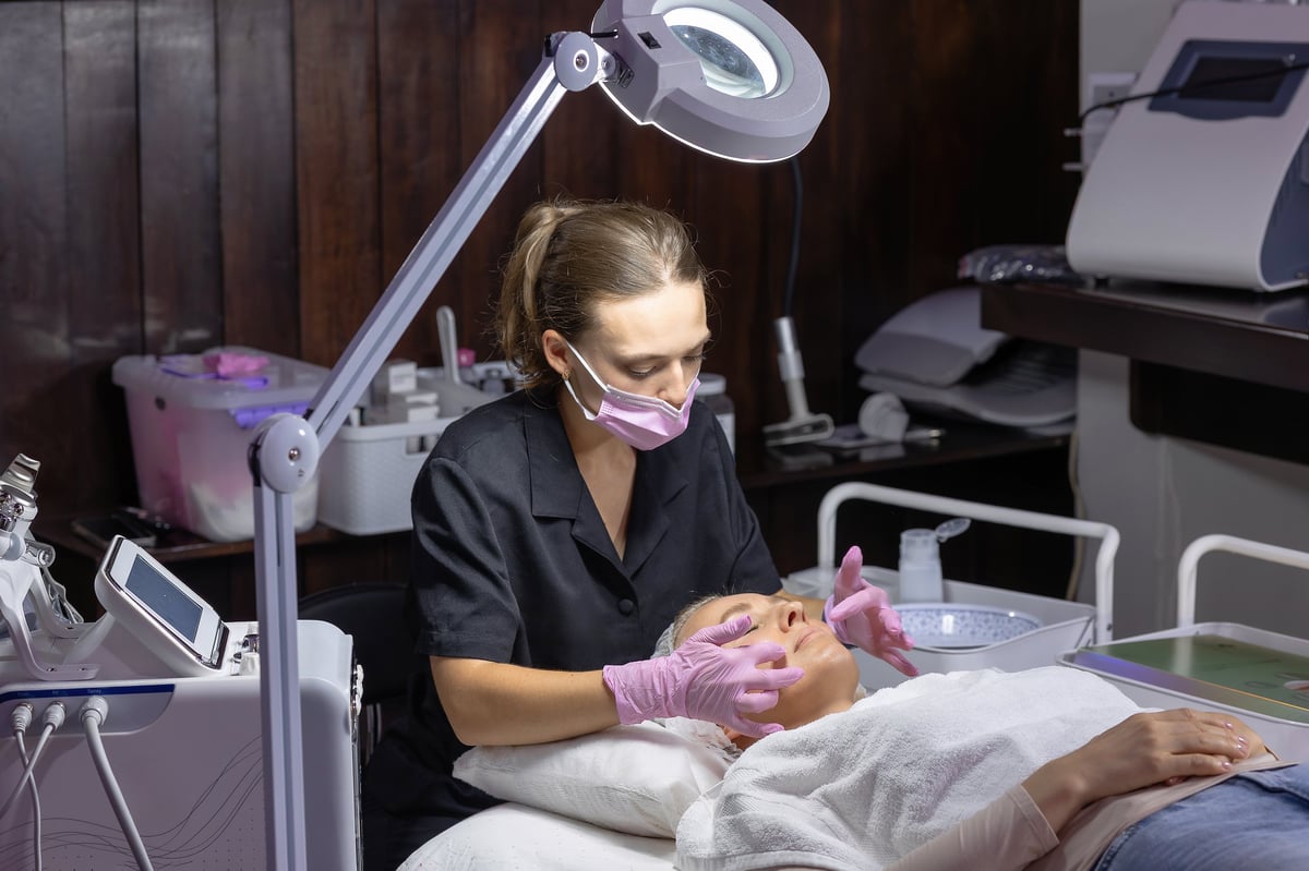 Aesthetician applying a skincare treatment to a relaxed client at a medical spa
